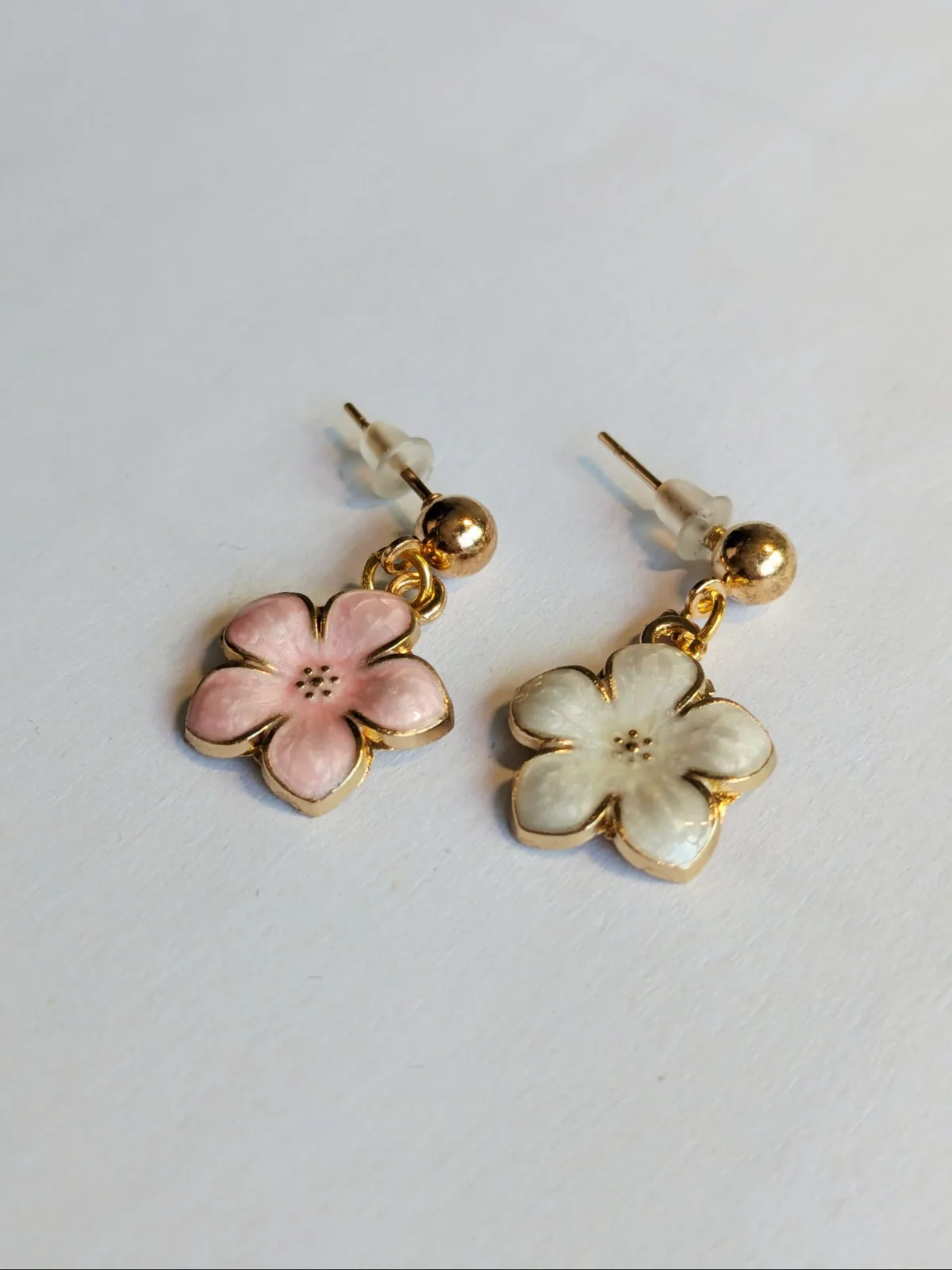Boucles d'oreilles puces fleur de cerisier dorées, une en émail rose et une en émail blanc nacré