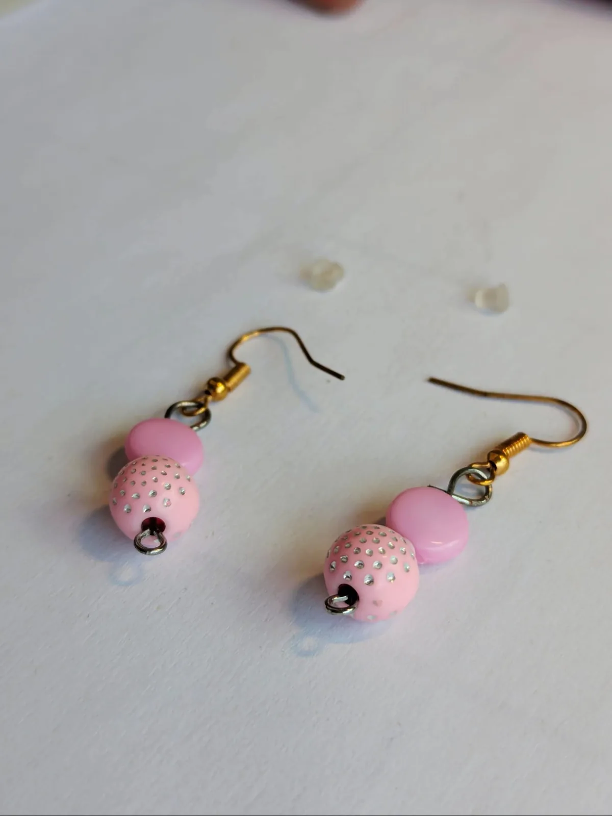 Boucles d'oreilles pendantes roses avec une perle plate rose unie et une perle ronde sertie de strass roses