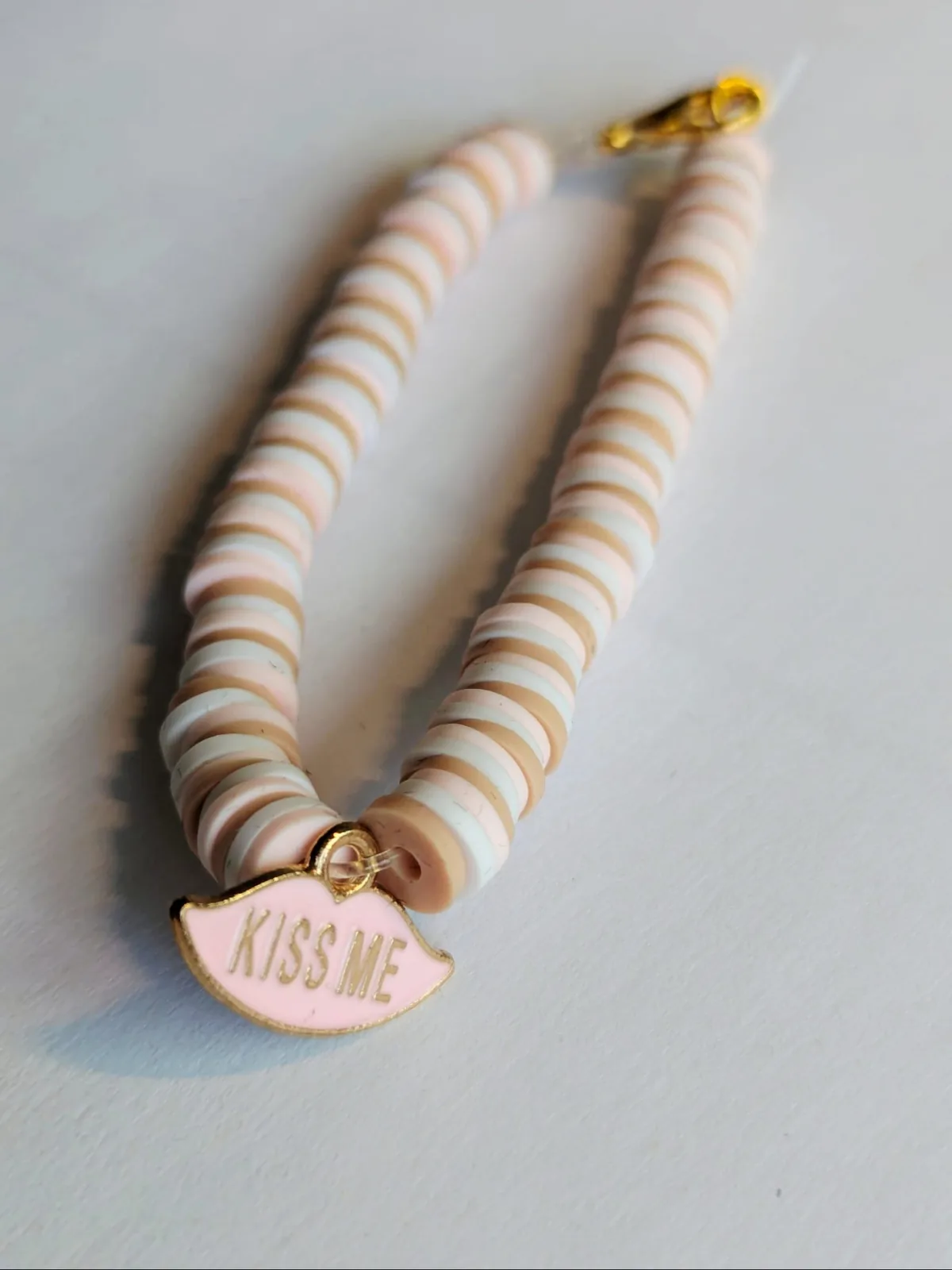 Bracelet en perles heishi roses, beiges et blanches avec breloque lèvres Kiss Me en émail rose et fermoir doré